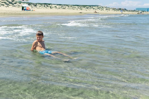 Happy boy swims and dives underwater. Active healthy lifestyle, water sports and activities with parents on summer family vacation with child. High quality photo