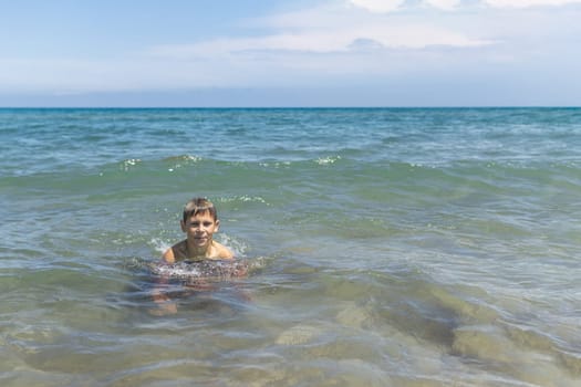 Happy boy swims and dives under water Active healthy lifestyle, water sports, seascape with a child there is a place for an inscription. High quality photo