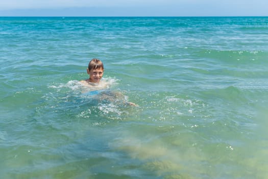 Happy boy swims and dives under water Active healthy lifestyle, water sports, seascape with a child there is a place for an inscription. High quality photo