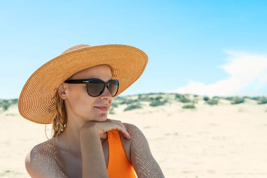 portrait of a girl in a swimsuit, glasses and a hat on the beach, Photo of a seascape with a girl. High quality photo