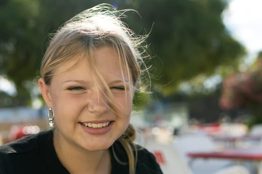 portrait of a teenage girl of European appearance with blond hair. The girl smiles and looks at the camera. There is a place for an inscription. High quality photo