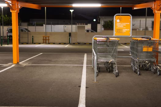 Many rows of orange trolleys outside the store with a close-up of the parking lot, there is a place for an inscription. High quality photo