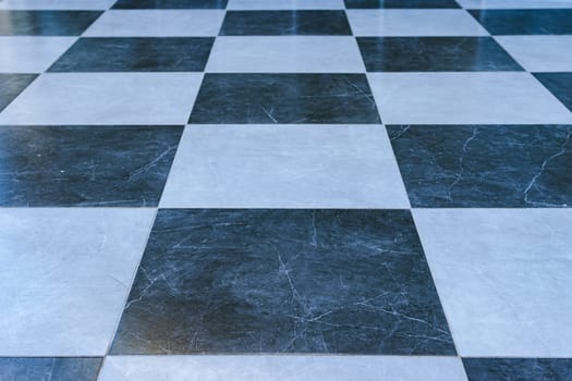 Builders laying tiles, new black and white tiles on the floor in the kitchen. Renovation concept. High quality photo