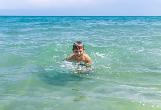 Happy boy swims and dives underwater. Active healthy lifestyle, water sports and activities with parents on summer family vacation with child. High quality photo