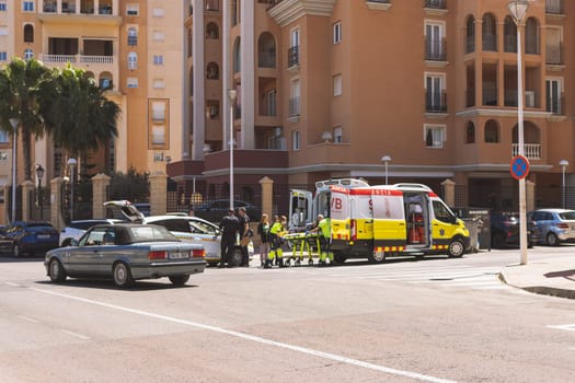 Spain, Torrevieja May 28, 2023, an ambulance on the road picks up a girl who was hit by a car on the road,. High quality photo