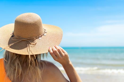 portrait of a girl with her back turned to the camera, close-up, the girl is standing in a brown hat and swimsuit, there is a place for an inscript. High quality photo