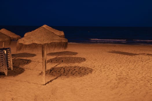 photo of a beautiful evening beach without people, clean evening beach, there is a place for an inscription. close-up on sun umbrellas on the beach High quality photo