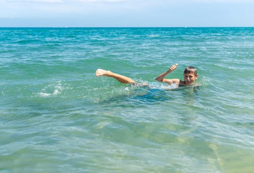 Happy boy swims and dives underwater. Active healthy lifestyle, water sports and activities with parents on summer family vacation with child. High quality photo