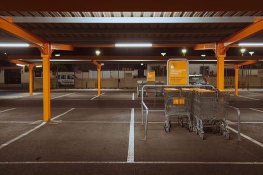 Many rows of orange trolleys outside the store with a close-up of the parking lot, there is a place for an inscription. High quality photo
