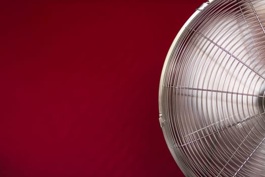 electric fan isolated on a red background, close-up on the left there is a place for an inscription. High quality photo