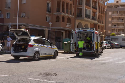 Spain, Torrevieja May 28, 2023, an ambulance on the road picks up a man who was hit by a car on the road, a resort town in Spain near the sea. High quality photo