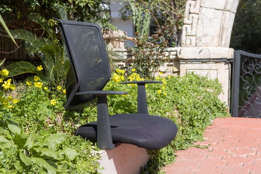 an old chair on the street in a provincial town stands on green grass. High quality photo