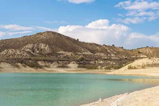 Beautiful landscape of nature, there is a place for an inscription. A lake with turquoise water close-up around small mountains. High quality photo