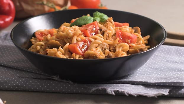 Italian Pasta with Tuna and Basil. Fresh pasta with tuna and tomato sauce on old wooden background.