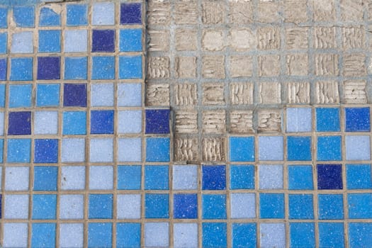 part of a wall in blue and blue mosaic close-up on a gray plastered wall.Renovation concept. High quality photo