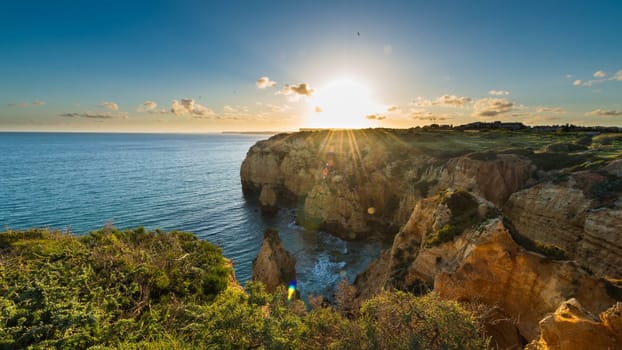 Sunset over the cliffs and beaches by Atlantic Ocean, Lagos, Algarve, Portugal.