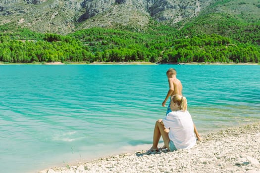 beautiful mountain landscape with a girl and a child against the backdrop of mountains and a lake. High quality photo