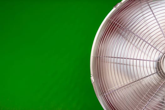 electric fan isolated on a green background, close-up on the left there is a place for an inscription. High quality photo