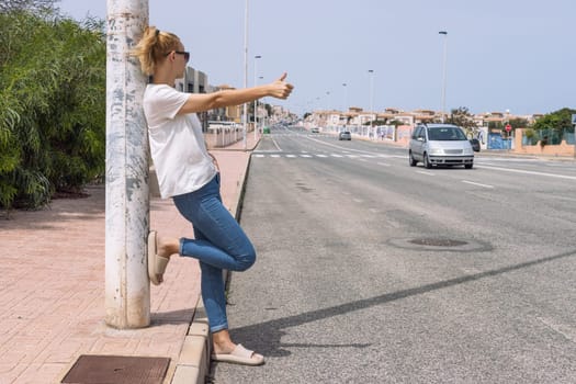 Young woman catches a car on the road, automatic stop, automatic braking, travel, travel. High quality photo