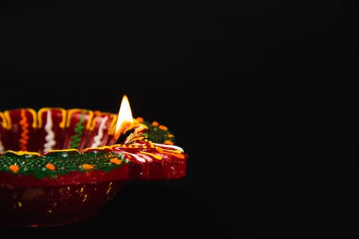 Light up your Diwali celebration with these shining clay diya lamps, symbols of prosperity and happiness, against a calming black background. Ideal for text overlays, greeting cards