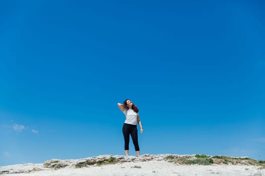 woman in sportswear standing under blue sky hiking walking trip
