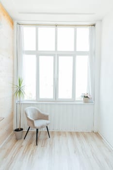 a large spacious bright room with chair and large window