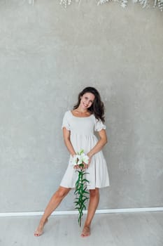 brunette woman in white dress with a white flowers