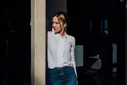 woman in a white shirt stands under the sun