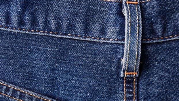 Seams on jeans close-up. Stitching on denim. Fabric texture. Blue jeans background and texture. Close up of blue jeans background. Denim texture in high-resolution.