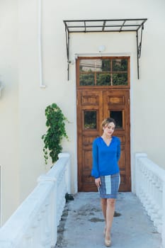 woman in blue clothes at a large wooden door