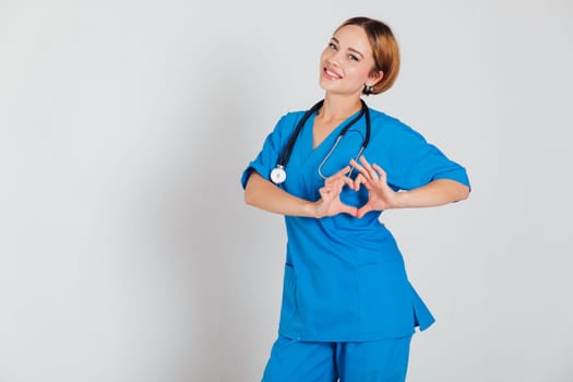 a doctor in a blue suit with a phonendoscope shows the heart