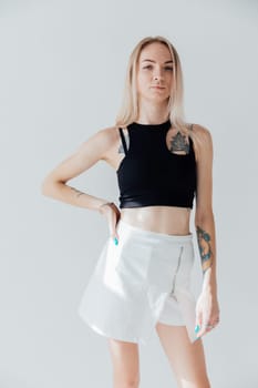 woman in a black T-shirt stands on a white background and poses