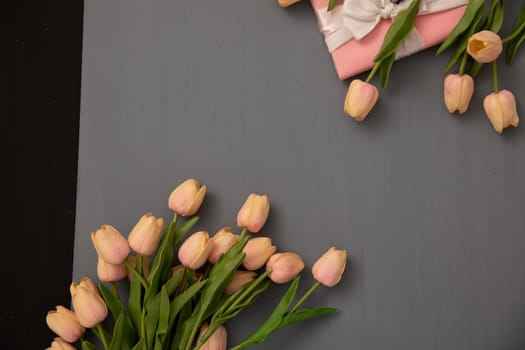 bouquets of tulips with gift on a grey background texture vintage