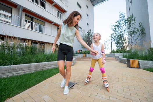 Mother helps daughter learn to roller skate