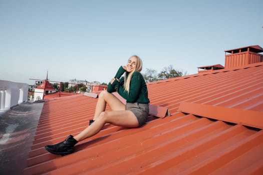 beautiful woman sitting on the roof of a house