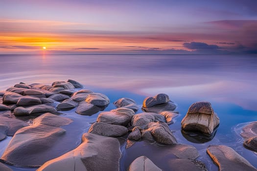 Sunset over the sea with stones on the foreground. Reflections.Sunset over the sea with stones in the foreground and reflection in water.