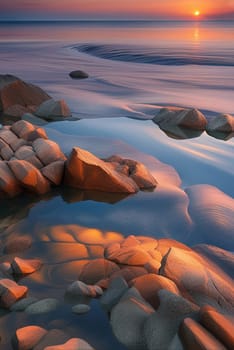 Sunset over the sea with stones on the foreground. Reflections.Sunset over the sea with stones in the foreground and reflection in water.