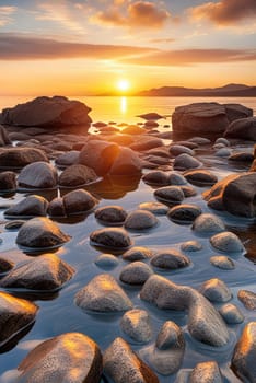 Sunset over the sea with stones on the foreground. Reflections.Sunset over the sea with stones in the foreground and reflection in water.