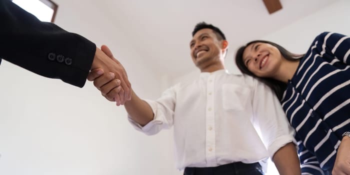 Couple asian handshake with a real estate agent after purchase a home.