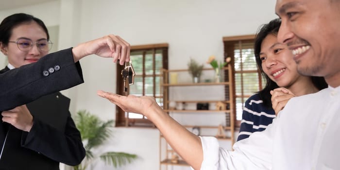 Happy couple asian buy their new home and receiv key from real estate agent.