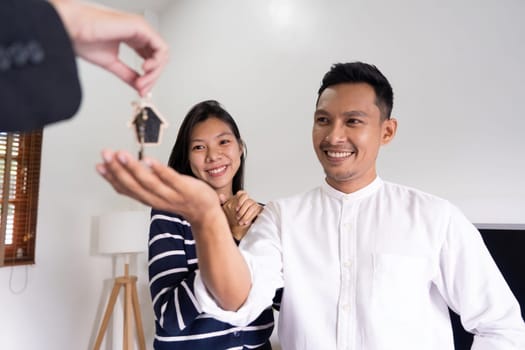 Happy couple asian buy their new home and receiv key from real estate agent.