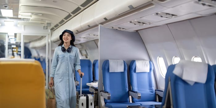 Young woman with a suitcase at the airplane.