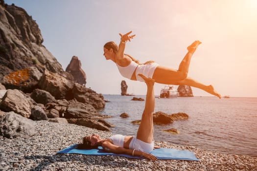 Woman sea yoga. Back view of free calm happy satisfied woman with long hair standing on top rock with yoga position against of sky by the sea. Healthy lifestyle outdoors in nature, fitness concept.