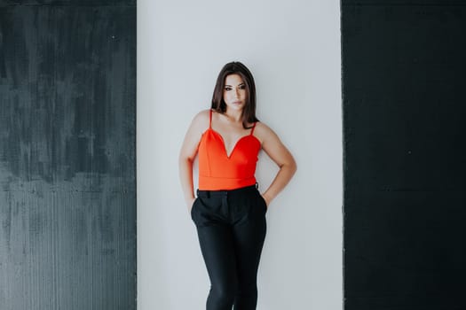 brunette in red poses against a black-and-white wall