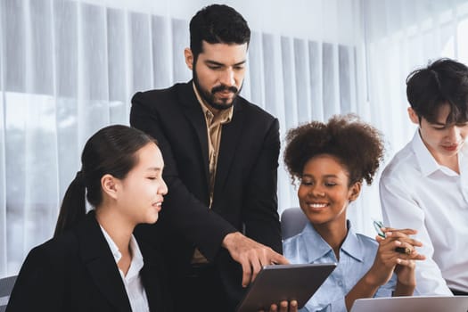 Happy diverse business people work together, discussing in corporate office. Professional and diversity teamwork discuss business plan on desk with laptop. Modern multicultural office worker. Concord