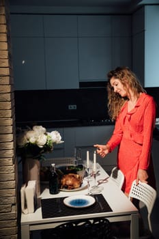 a beautiful woman in red dress lights candles dinner by candlelight