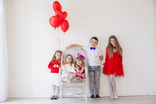 fancy kids with Valentine's Day balls sitting on a chair