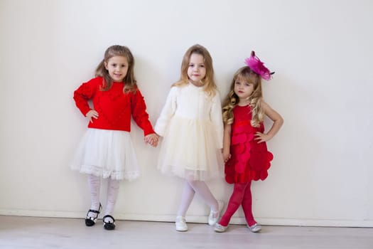 a elegant little girls posing on a white background indoors