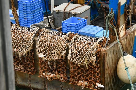 Red rusty boats and metal nets for catching scallops