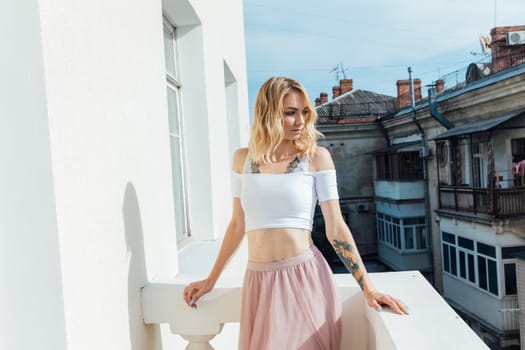 woman in light clothes stands on the balcony